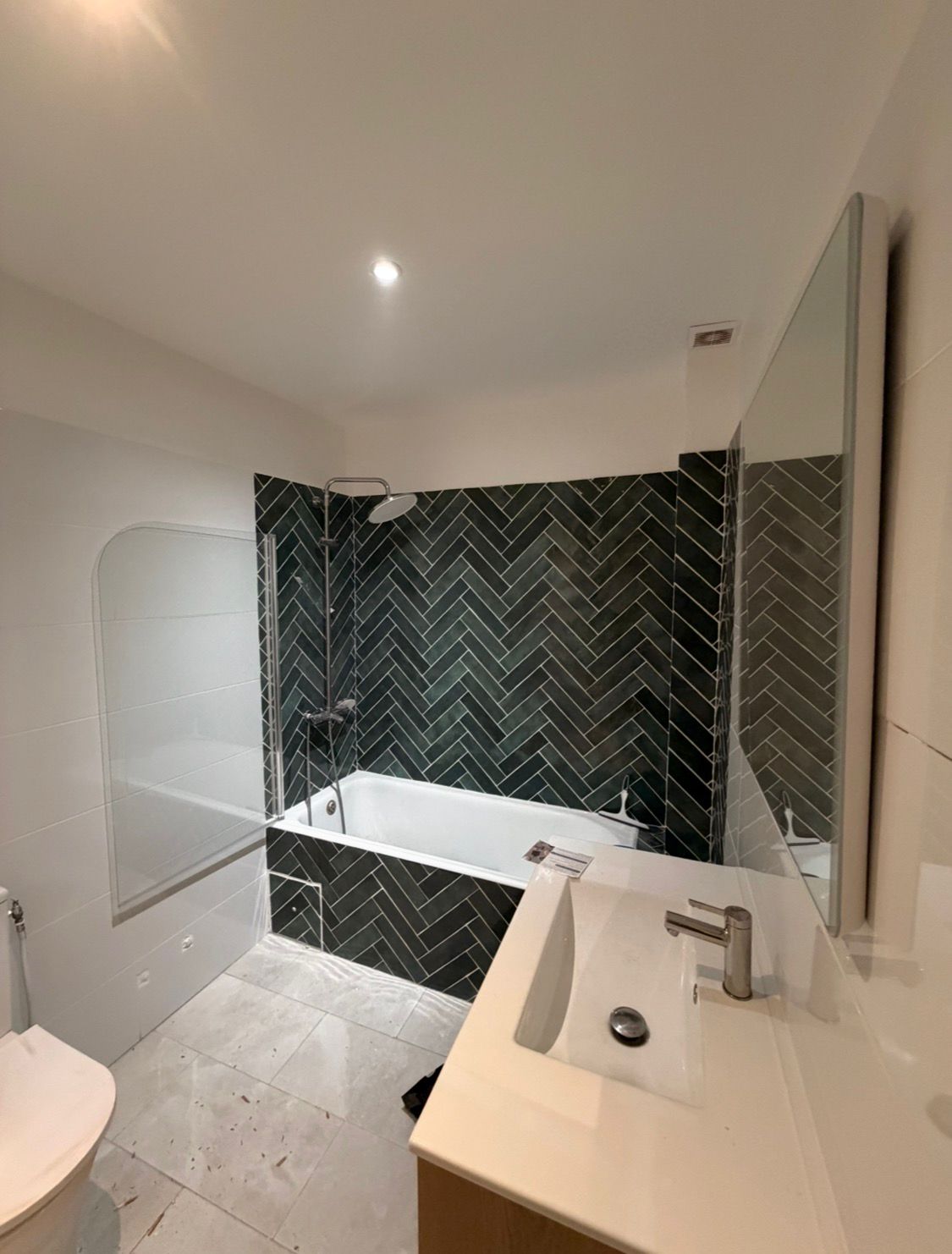 Salle de bain avec baignoire et carrelage vert chevron par BAT FINITION